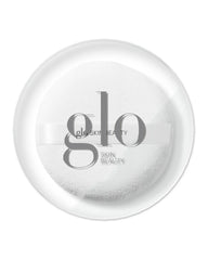 Weiße Puderquaste mit Schleifenband und Glo Skin Beauty Logo, präsentiert in einer transparenten runden Dose.
