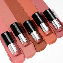 Fünf rosé-nudefarbene Glo Skin Beauty Lippenstifte auf passenden Farb-Swatches.