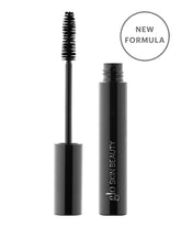 Glo Skin Beauty Mascara in schwarzer Tube mit abgetrennter Bürste und rundem Badge „NEW FORMULA“ auf der Verpackung.