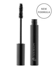 Glo Skin Beauty Mascara in schwarzer Tube mit abgetrennter Bürste und rundem Badge „NEW FORMULA“ auf der Verpackung.
