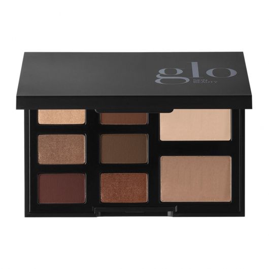 Schwarzes Kompakt, beschriftet mit Glo Skin Beauty, mit neun neutralen Lidschatten und zwei größeren Face-Pans, Farbton The Velvets
