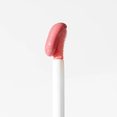 Rosa Lipgloss-Applikator mit glänzendem Swatch auf weicher Doe-Foot-Spitze vor weißem Hintergrund