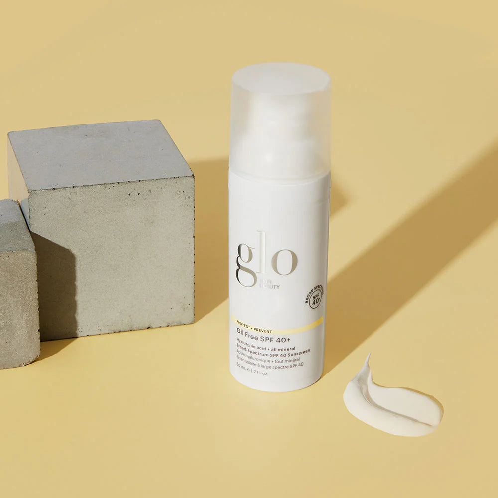 Glo Skin Beauty Öl-freie SPF 40+ Sonnencreme Flasche mit Creme auf gelbem Hintergrund – Breitbandschutz gegen UVA und UVB