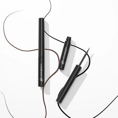 Zwei schwarze Glo Skin Beauty Liquid Eyeliner mit gezeichneten braunen und schwarzen Lidstrichen.