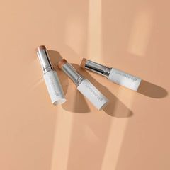 Glo Skin Beauty Skin Glow Stick Highlighter: Drei Creme-Highlighter-Stifte auf Pfirsich-Hintergrund